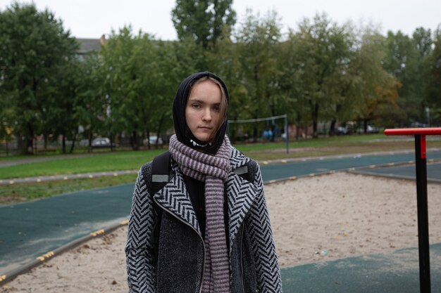 Girl teenager in autumn clothes on a city street