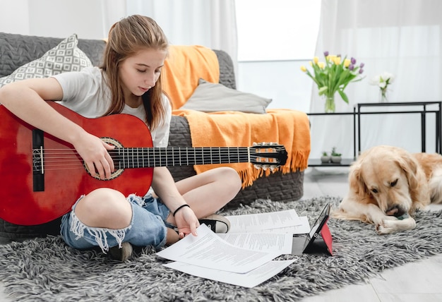 10 代の少女のギター演奏の練習