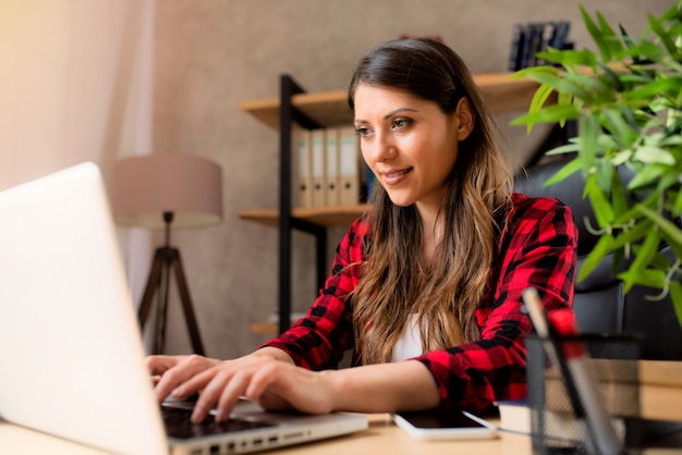 여자 teleworker는 집에서 노트북으로 작동