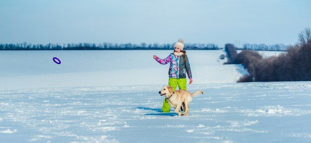 Girl throwing ring to dog