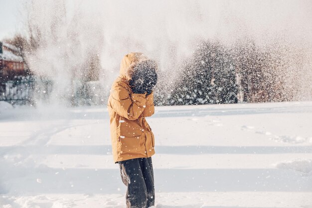 女の子は空中に雪を投げます