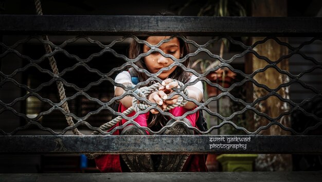 Photo girl tied with rope on metal railing