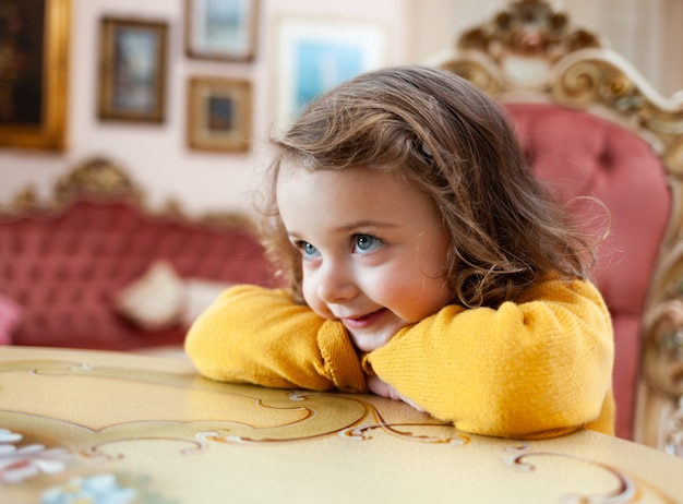 Girl toddler in a living room with baroque decor.