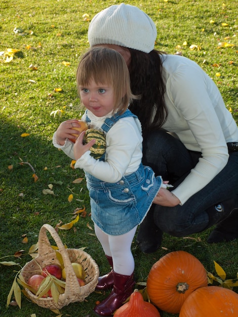 Girl toddler with her mother in autumn park.