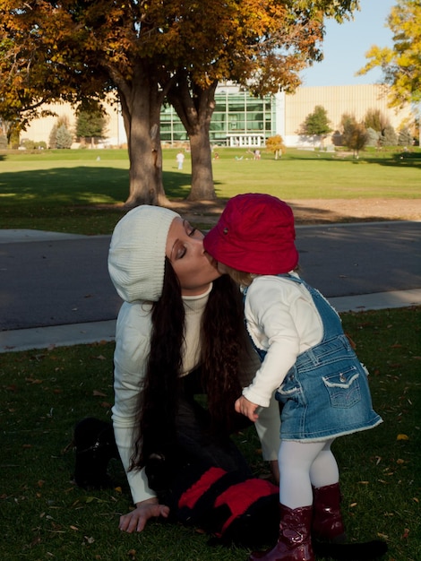 Girl toddler with her mother in autumn park.