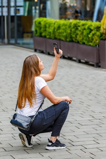 女子観光客が携帯電話で街の景色を撮影する