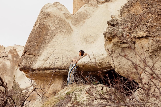 Девушка-туристка отдыхает возле пещер в Каппадокии. Турция