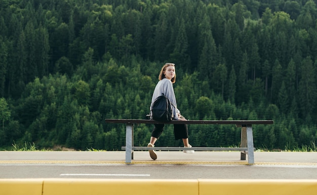 Girl tourist uses internet on smartphone on balcony in mountain