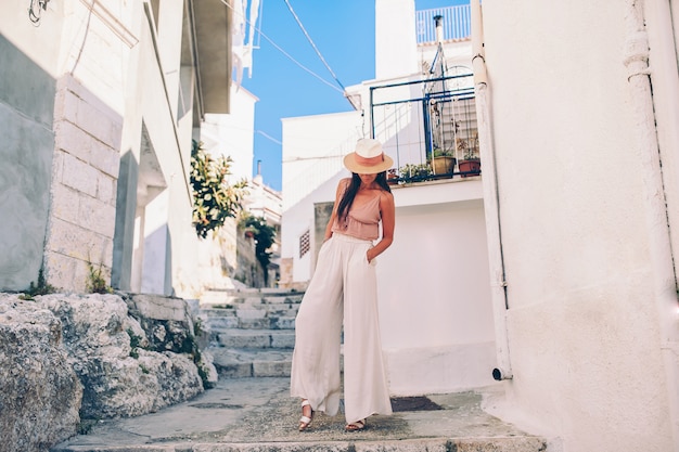 Girl tourist walks outdoors in narrow street