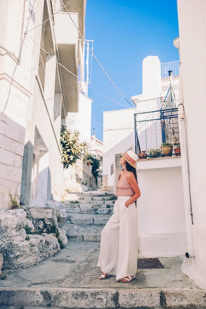 Girl tourist walks outdoors in narrow street