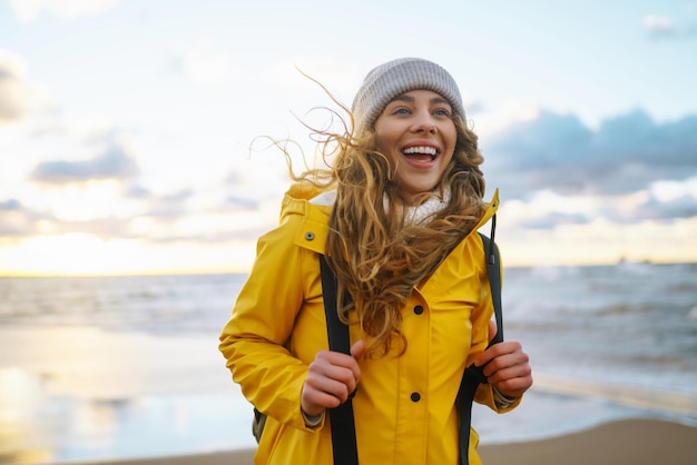 The girl tourist in a yellow jacket posing by the sea Travelling lifestyle adventure