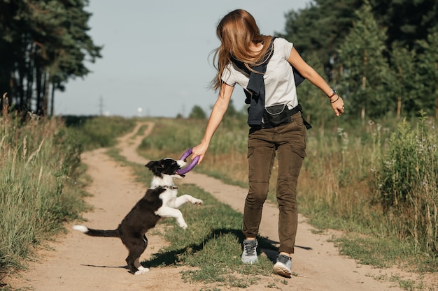 Girl training black and white border collie dog puppy