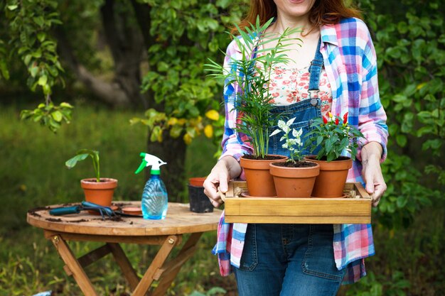 女の子は庭に花を移植します。植木鉢や移植用植物