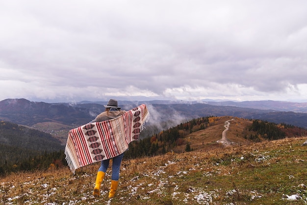 Фото Девушка-путешественница в горах в одежде бохо и шляпе наслаждается природой и путешествует концепция местного кемпинга