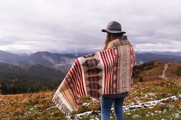 帽子をかぶった自由奔放に生きる服を着て山の女の子旅行者自然と旅行を楽しむ地元のキャンプのコンセプト