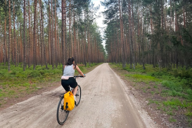 A girl traveling in the woods by bicycle Concept of recreation in nature