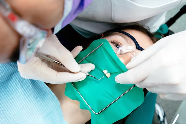 The girl treats teeth at the dentist