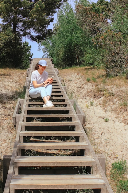 A girl on a trip uses a technical device to post photos or videos on social networks summer walk