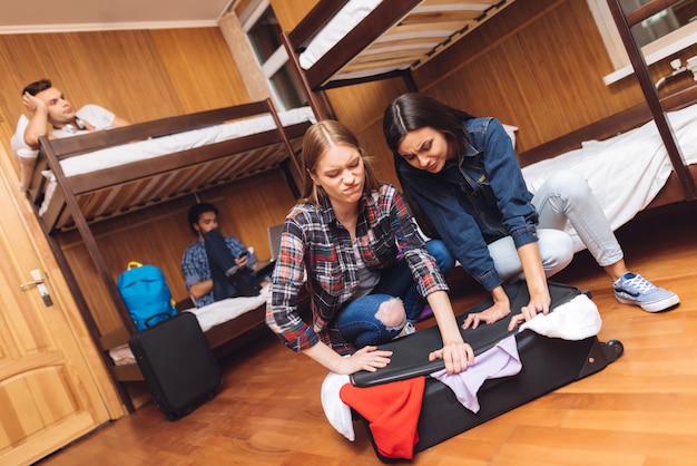 Foto la ragazza che prova aiuta la valise vicina della ragazza.