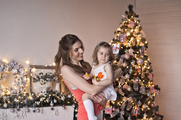 The girl turns the baby around the glittering Christmas tree 9465