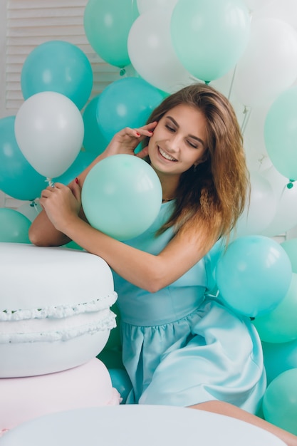 Girl in turquoise dress with balloons