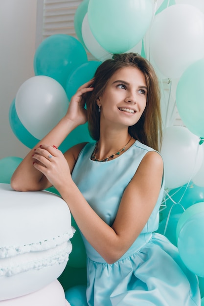 Girl in turquoise dress with balloons