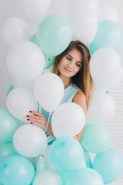 Girl in turquoise dress with balloons