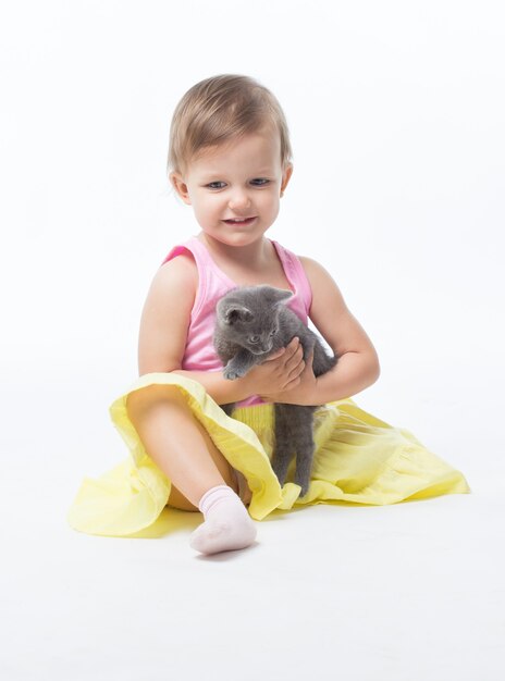 Girl two years playing with a kitten