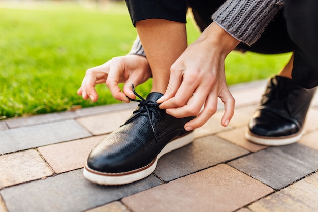 Girl tying shoelaces on moccasins on the street