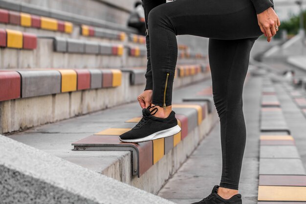 girl tying shoelaces on sneakers