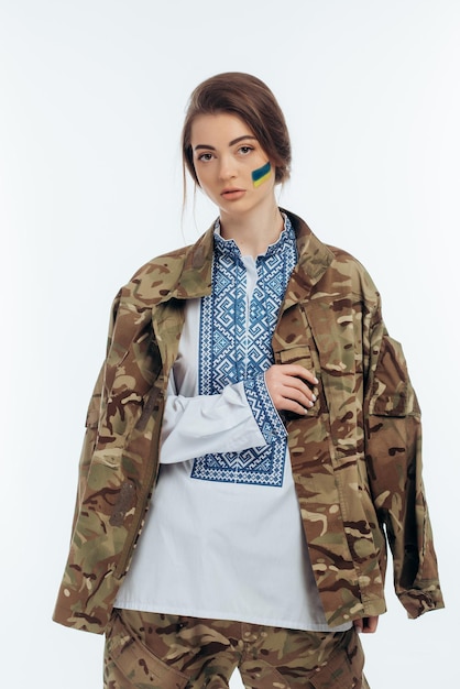 Photo a girl in ukrainian vyshyvanka holds a flag war in ukraine on a white background