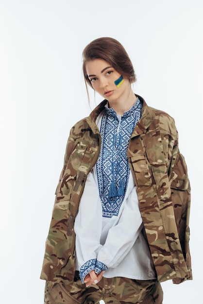 A girl in Ukrainian vyshyvanka holds a flag War in Ukraine on a white background