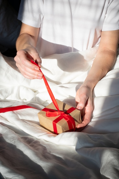 Girl unpacks a gift in bed in the morning