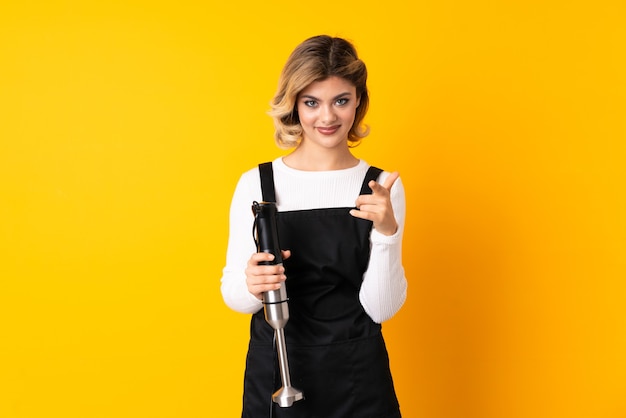 Girl using hand blender pointing front