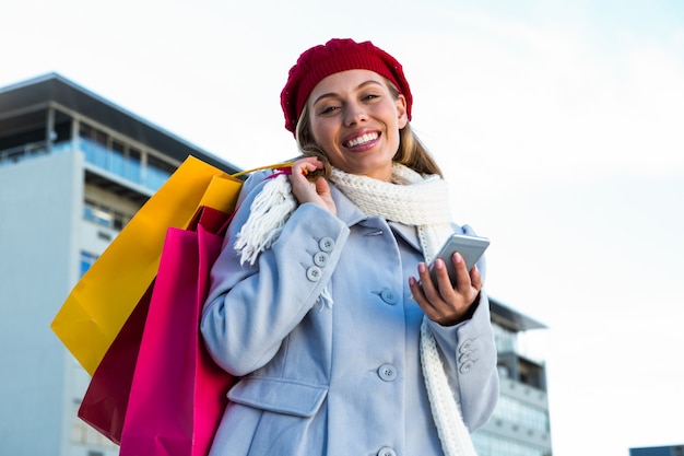 Girl using at her phone during shopping outisde