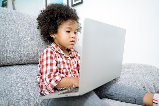 Photo girl using laptop while sitting on sofa in living room at home