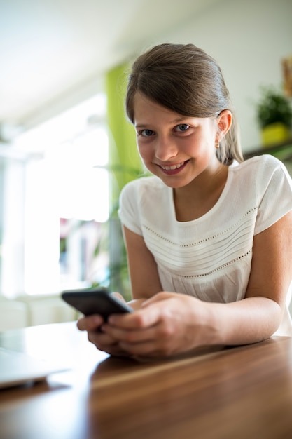 Ragazza che utilizza telefono cellulare nel salone