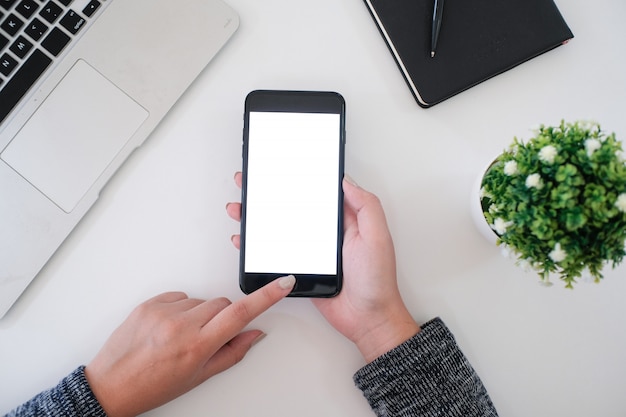 girl using smart phone in office. hand holding smart phone white screen