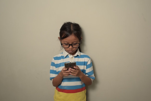 Girl using smartphone and looking at the screen with a confident expression on smart face thinking