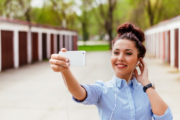 Girl using smartphone for video conversation outdoors