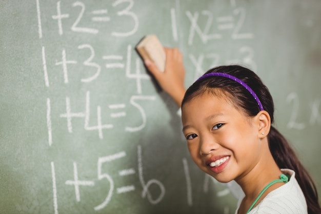 Girl using a sponge for blackboard