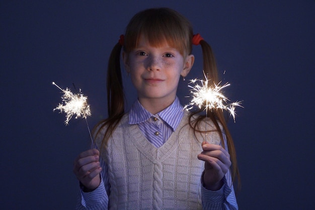 Girl in the vest holding the sparkles