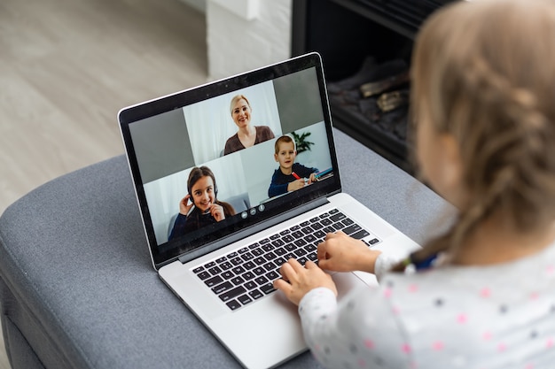 A Girl Video Conferencing With Happy Female Teacher On Laptop