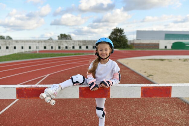 スタジアムでヴィンテージの白いローラー スケートとヘルメットの女の子