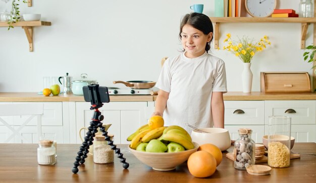 Photo a girl vlogger records video content for a culinary blog a cheerful girl shares her secrets on the a...