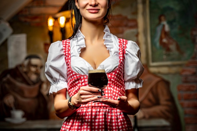 The girl waiter carries a glass of beer