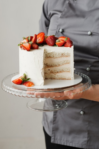 Girl waiter holding a piece of cake on a transparent tray in her hands