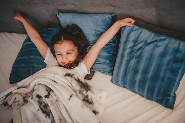 a girl wakes up after sleeping in her bed