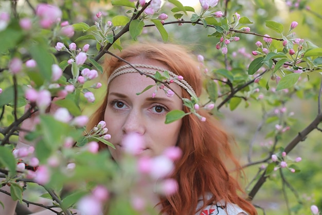 A girl on a walk in an autumn park. Young red-haired girl in the spring on nature.