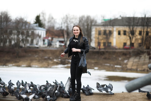 A girl on a walk in the park and a flock of pigeons